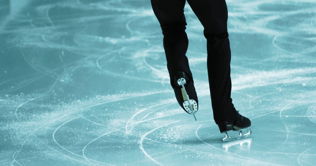 リンクを滑る男子選手の後ろ姿の足元