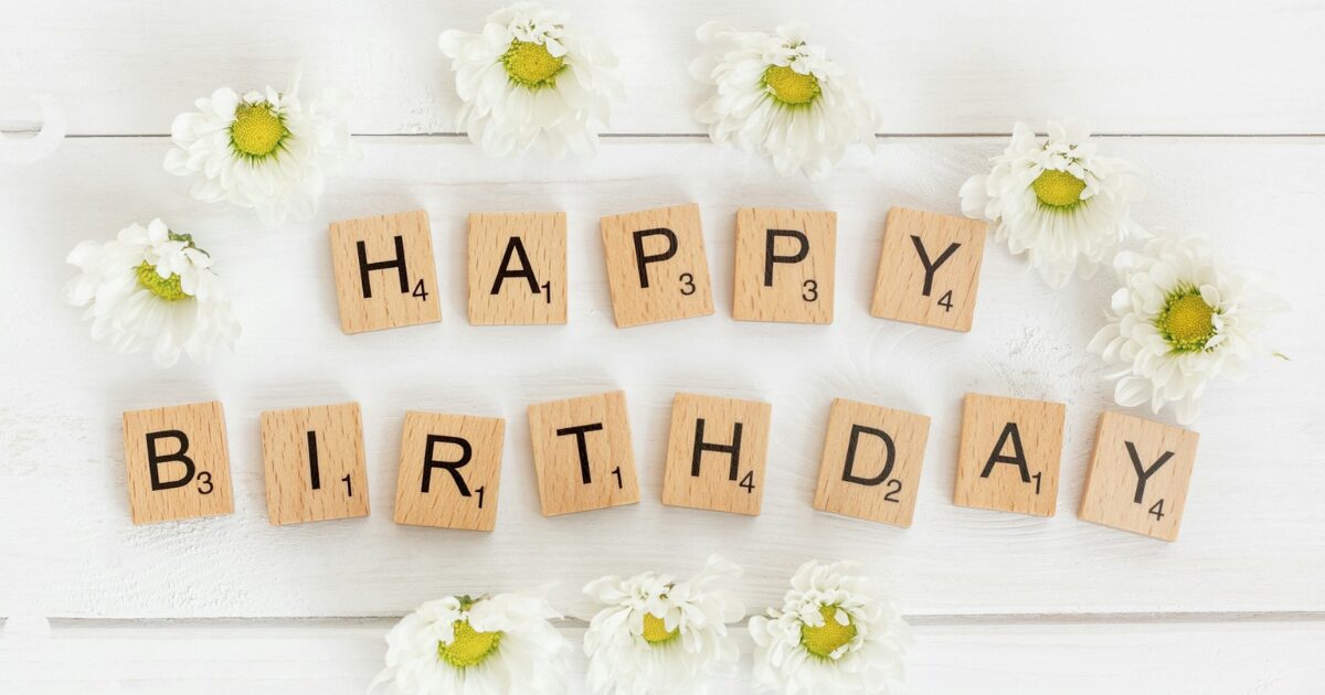 白い壁に白い花とHAPPY BIRTHDAYの文字