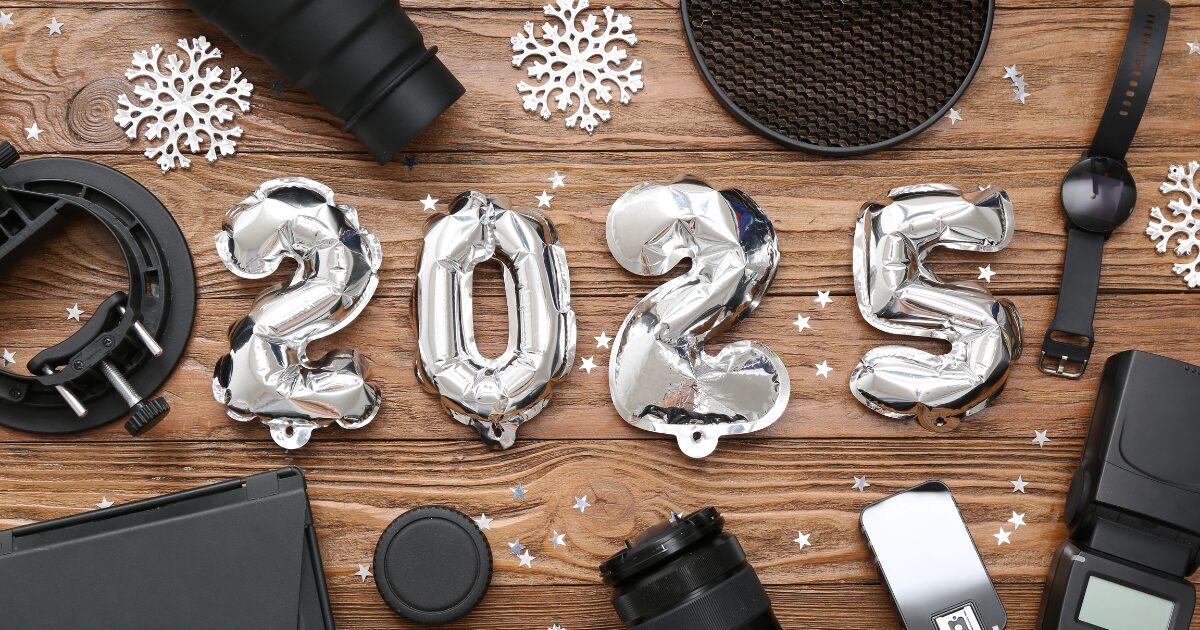 2025 の形をした銀色のバルーンの周りに雪の結晶のオーナメントとカメラ機材等が散らばっている写真
