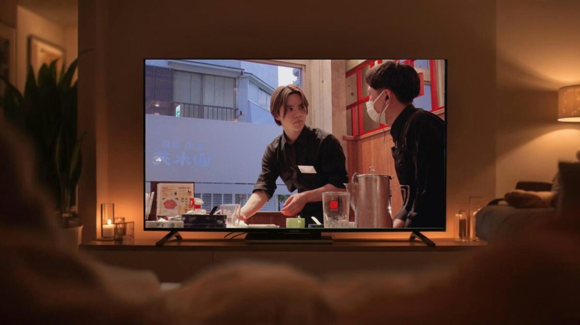 暗い部屋のテレビモニターに焼肉店でバイトする宇野昌磨さんが映っている画像